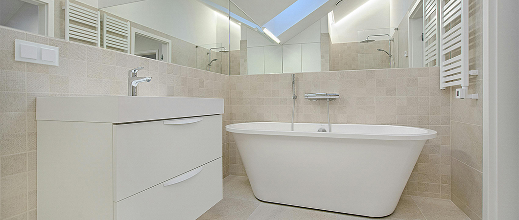 Modern remodeled bathroom featuring updated tile, a glass shower enclosure, and new vanity with stylish lighting.